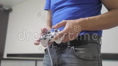 男人概念玩游戏垫手视频控制台在电视上。 玩家玩游戏与游戏垫控制器。 手拿新的操纵杆